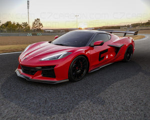 Side view of Corvette C8 Z06 ERAY ZR1 with a carbon fiber spoiler on a race track, captured at sunset