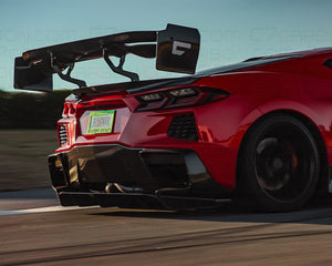 Corvette C8 Legacy Edition with a rear-mounted spoiler, side view while driving on a track.