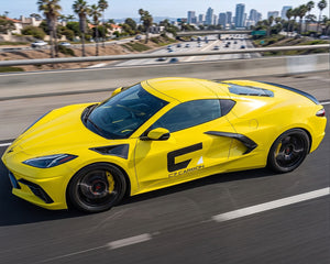 Side angle highway view of C8 Corvette Stingray featuring low profile carbon fiber spoiler