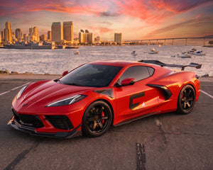 Front three quarter view of red C8 Corvette Stingray featuring Z06 style carbon fiber rocker panels