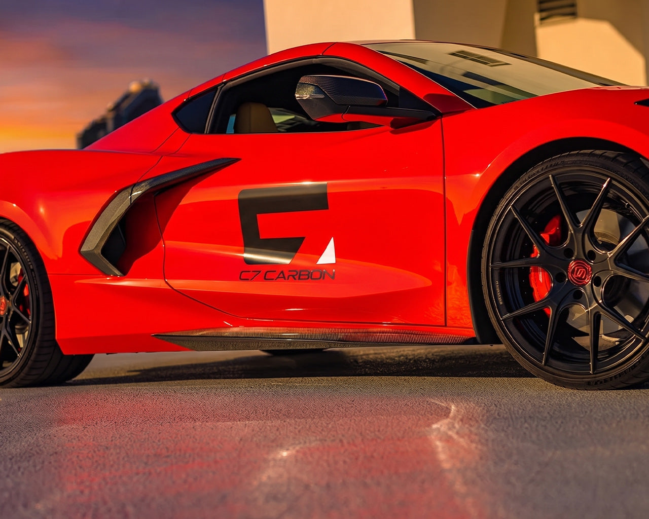Full side rocker panel profile of red C8 Corvette showing Z06 aerodynamic side splitter line