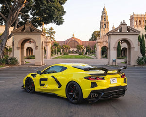 Full car rear profile of yellow C8 Corvette showing Z06 style chassis mounted track wing assembly