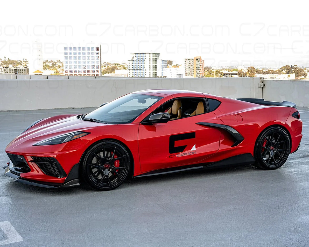 Front three quarter view of red C8 Corvette equipped with carbon fiber ducktail spoiler
