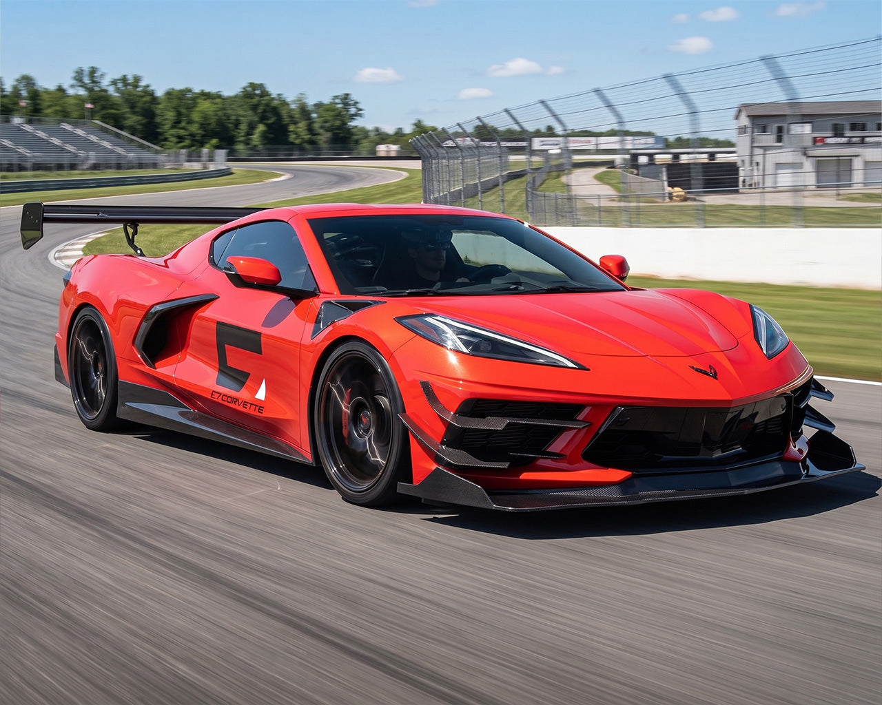 Red C8 Corvette with full aero package and Daytona chassis mounted track wing on race circuit