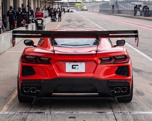 Direct rear view of red C8 Corvette in pit lane with Daytona chassis mounted carbon fiber track wing