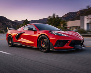 Red C8 Corvette driving on road equipped with low-drag Legacy Edition carbon rocker panel splitters