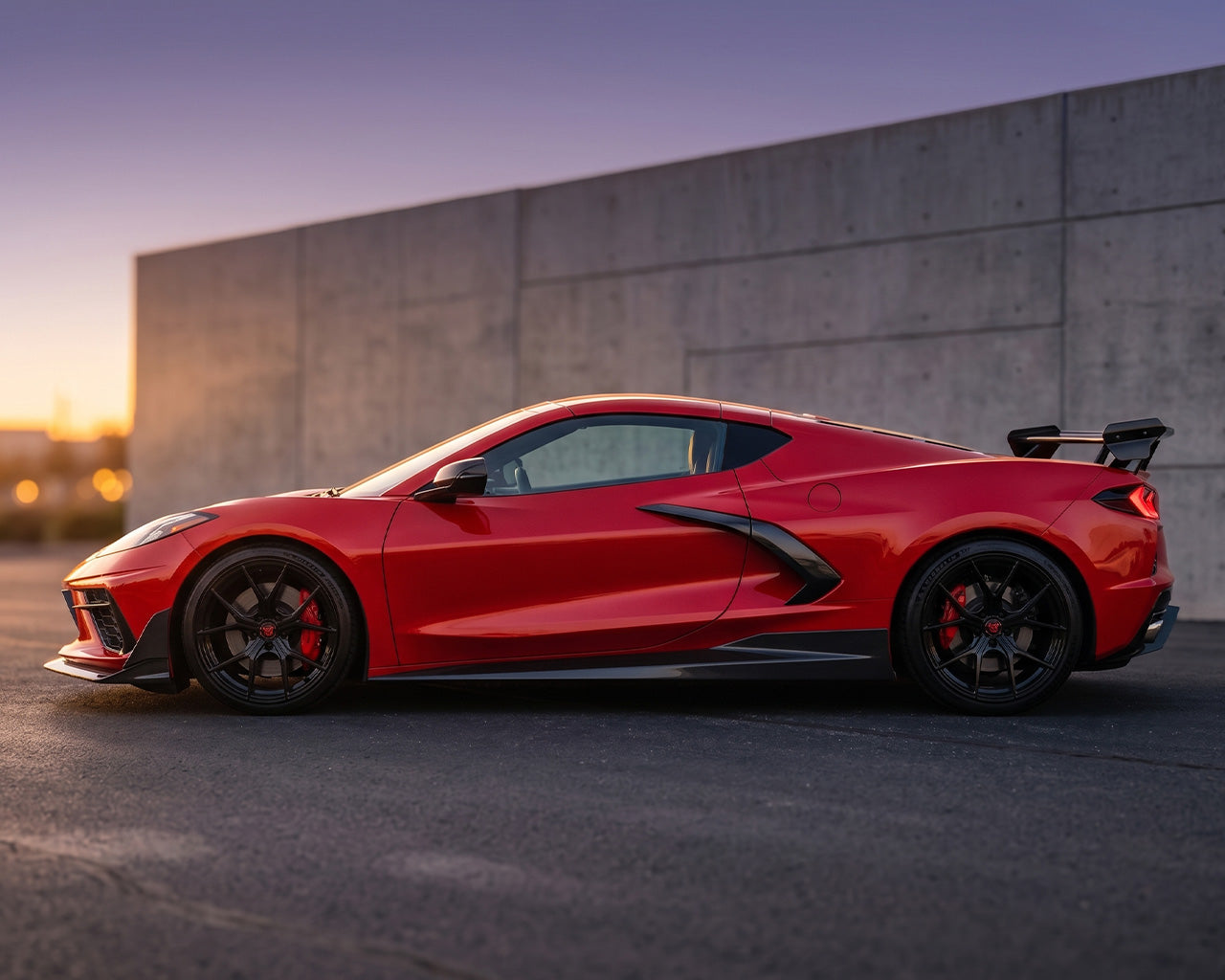 Full side profile stance of red C8 Corvette showing sleek Legacy Edition carbon side skirt aerodynamic lines