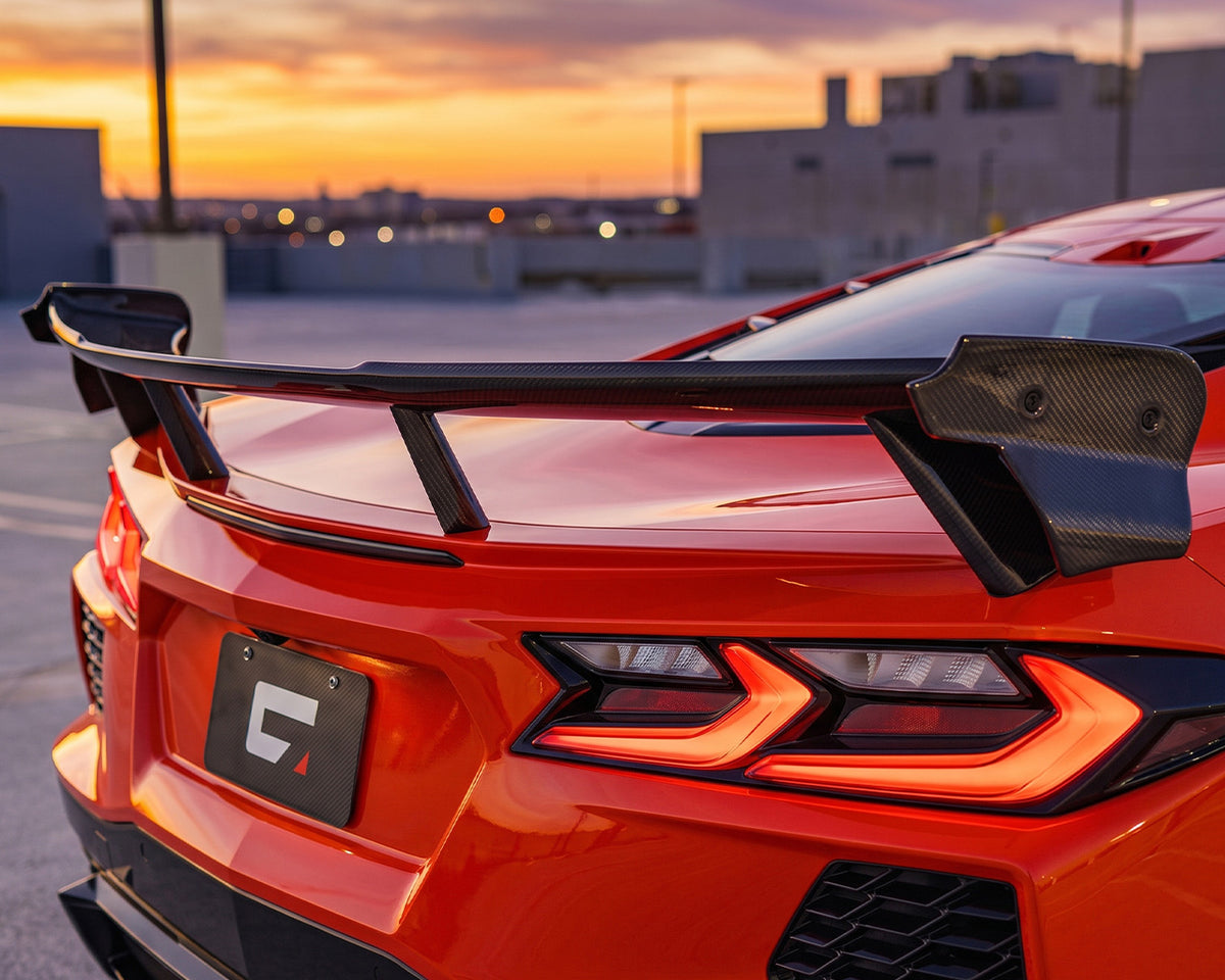 Direct rear taillight view of red C8 Corvette showing carbon fiber performance high wing uprights and blade
