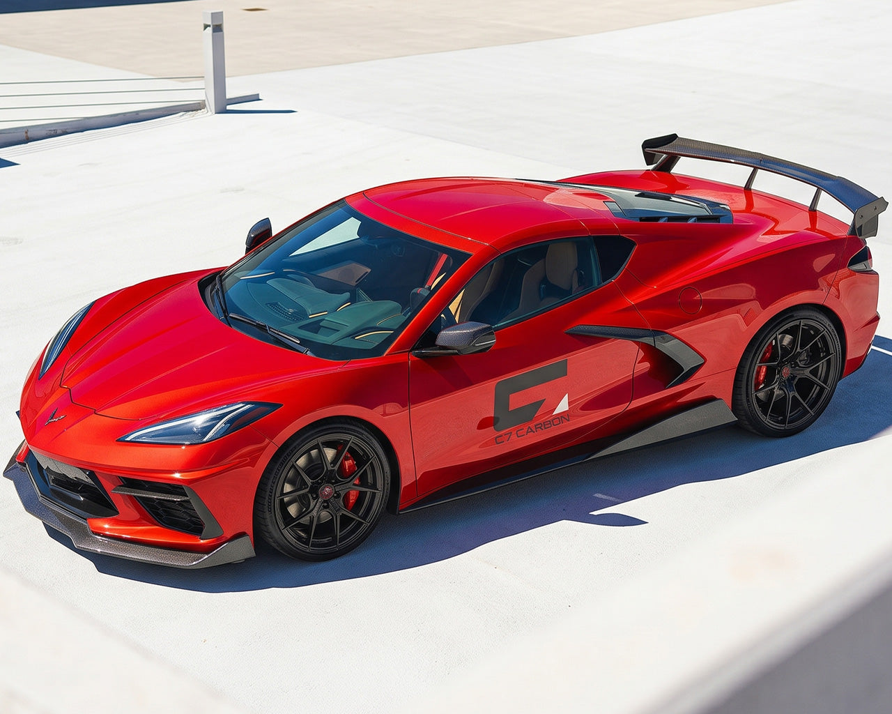 Overhead high angle view of red C8 Corvette coupe featuring carbon fiber aero and high wing