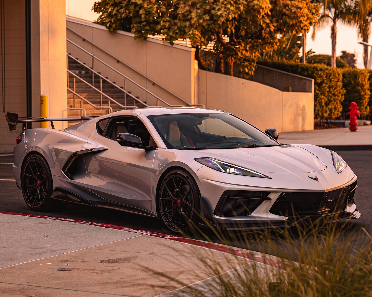 Front three quarter view of white C8 Corvette Stingray equipped with carbon fiber aero and race wing