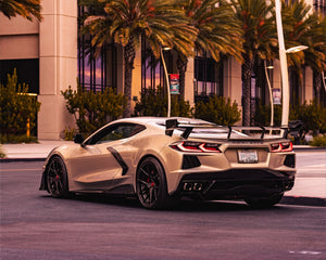 Rear quarter angle of white C8 Corvette coupe showing aggressive Race Edition carbon high wing spoiler