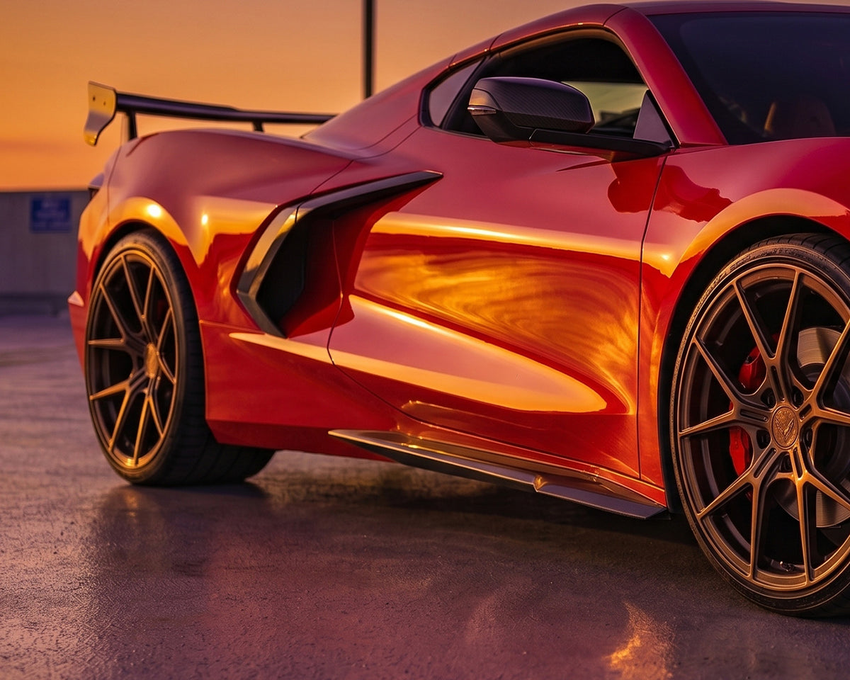Close up view of Z06 style carbon fiber side skirt installed on red C8 Corvette Stingray