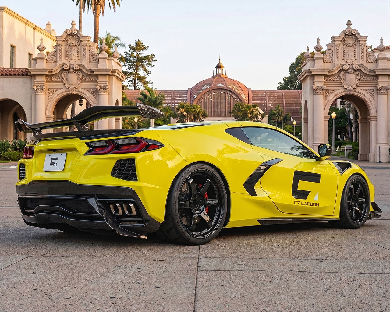 Rear three quarter view of yellow C8 Corvette featuring chassis mounted carbon fiber Z06 wing and ducktail spoiler