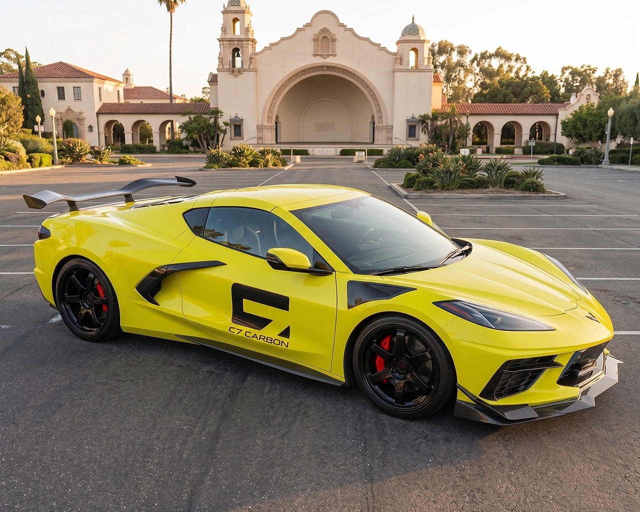 Front three quarter angle of yellow C8 Corvette coupe equipped with full carbon fiber aero and chassis mount wing