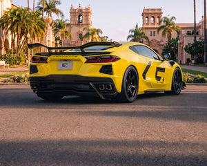 Low direct rear stance of yellow C8 Corvette Stingray showing chassis upright brackets and integrated decklid ducktail