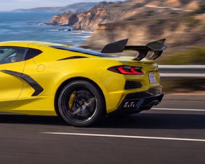 Coastal highway drive view of yellow C8 Corvette with pre-preg carbon fiber ZR1 high wing