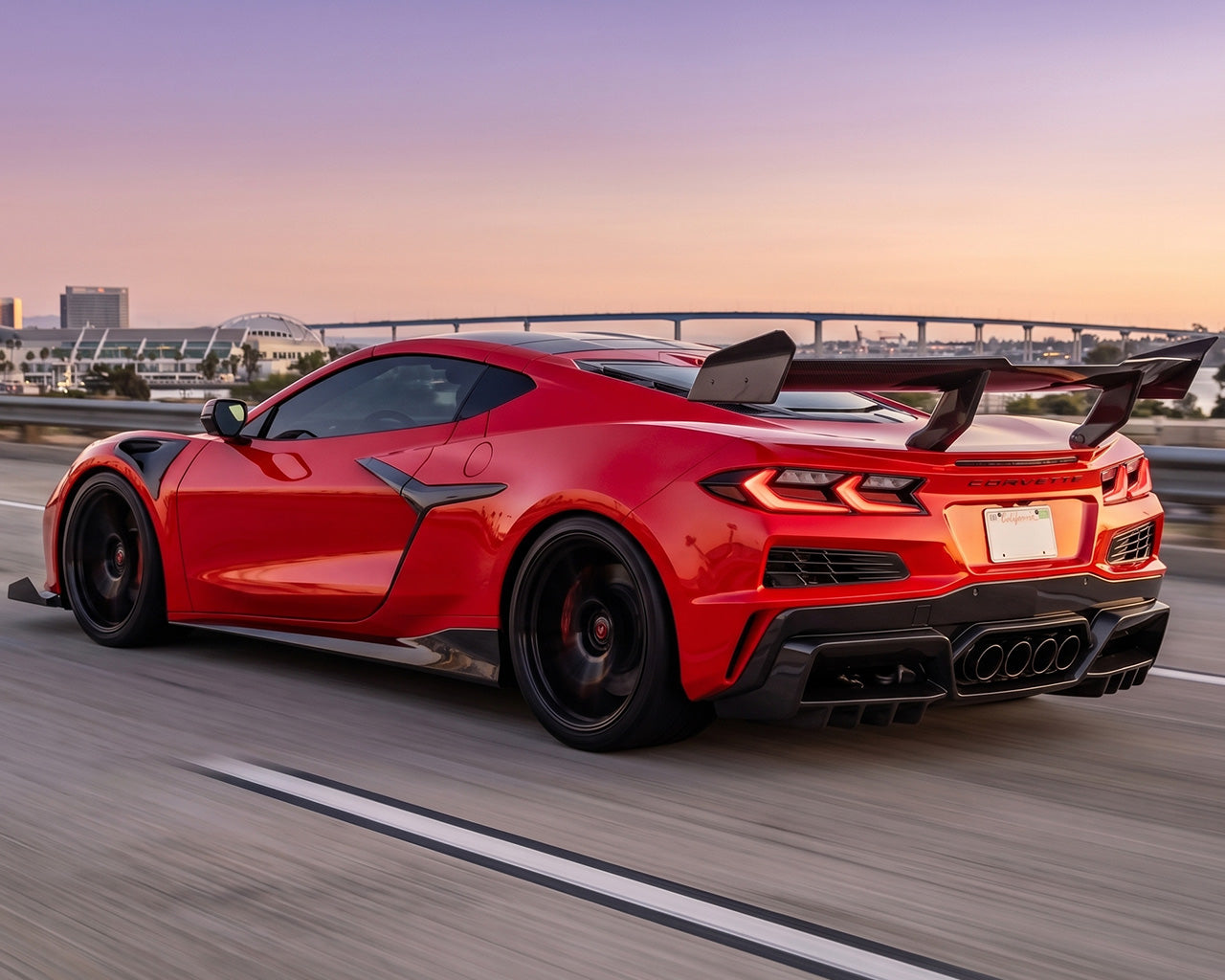 Rear three quarter action shot of red widebody Corvette C8 Z06 driving with Legacy Edition GT3 carbon fiber side skirts