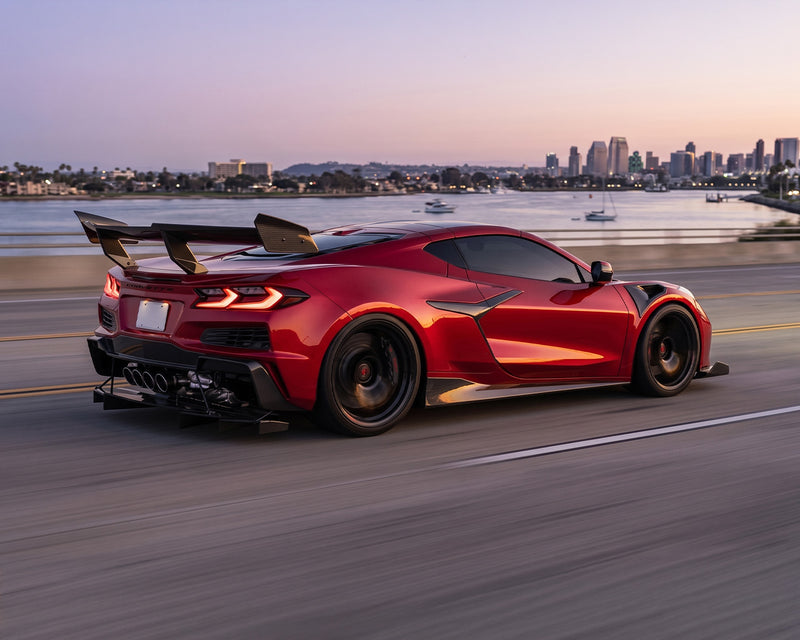 Low rear three quarter view of red Corvette C8 Z06 with track-focused Legacy Edition carbon fiber ground effects