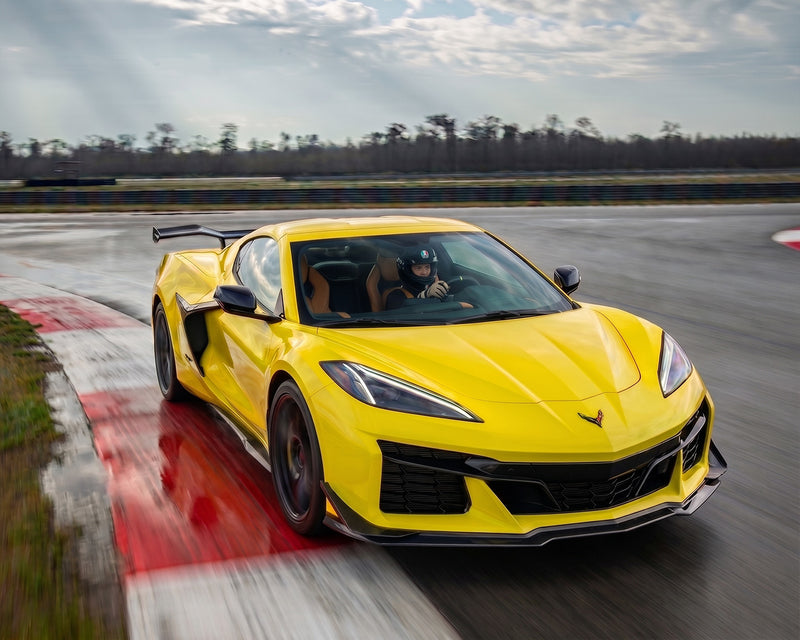 Track driving shot of yellow C8 Corvette Z06 with functional aerodynamic carbon fiber ground effects package
