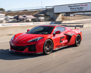 Front three quarter view of red C8 Corvette Z06 equipped with carbon fiber aerodynamic high wing