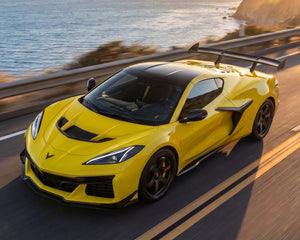 High angle road view of yellow C8 Corvette Z06 with pre-preg ZR1 carbon fiber rear wing spoiler