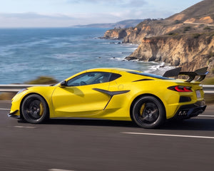 Side profile view of yellow C8 Corvette Z06 featuring track package carbon fiber rear wing