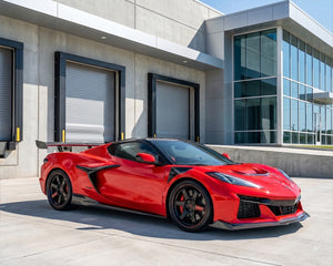 Red C8 Corvette Z06 coupe parked outside showing full carbon fiber exterior aero and rear wing