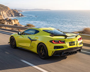 Yellow C8 Corvette Z06 cruising on coastal highway with carbon fiber Z07 high wing